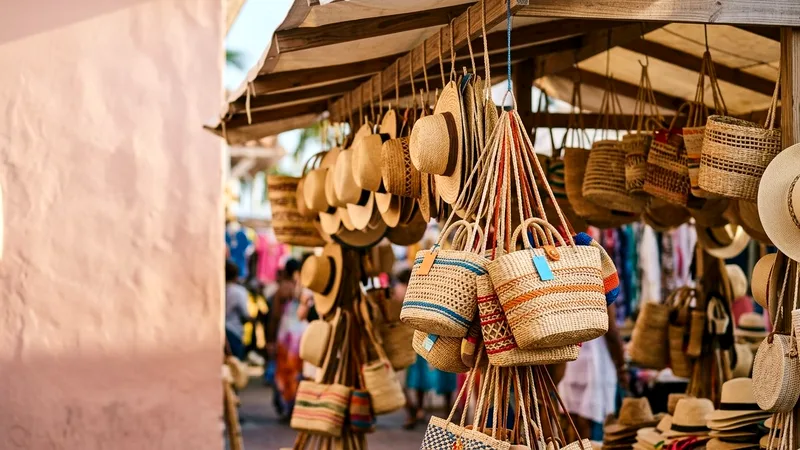 Woven straw hats and baskets hanging at a Nassau market stall.